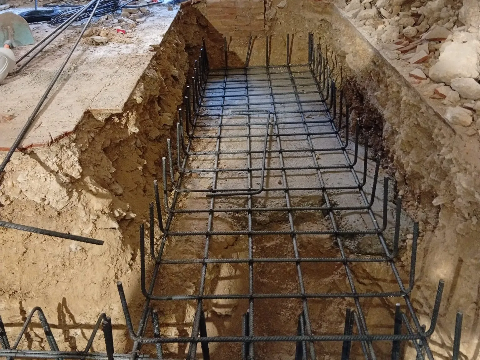 Zanja armada con acero para la nueva cimentación, dentro del edificio en rehabilitación en Banyoles.