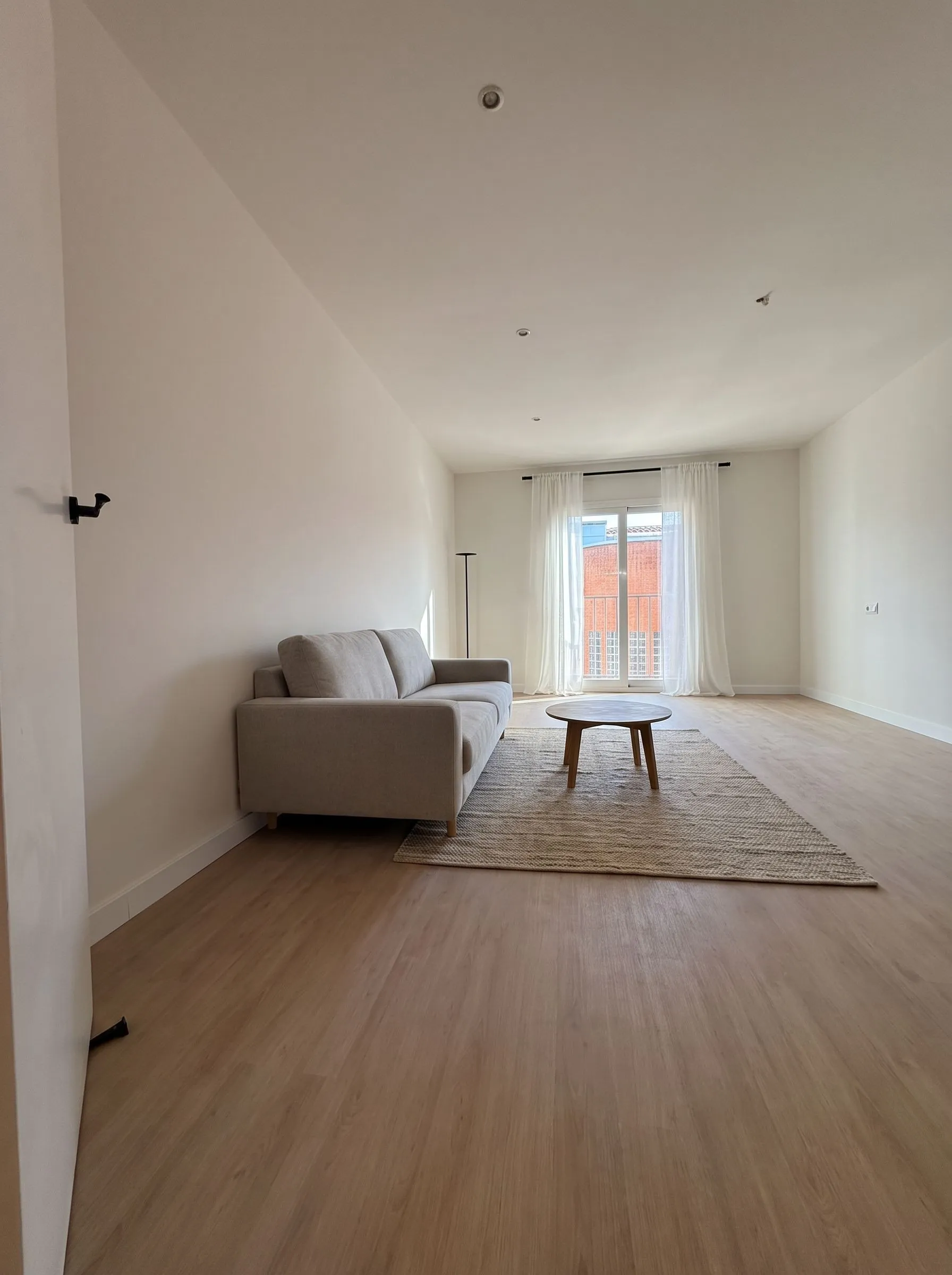Salón entregado en Girona, Carrer Astúries, con tarima de roble, balconera y luz natural.